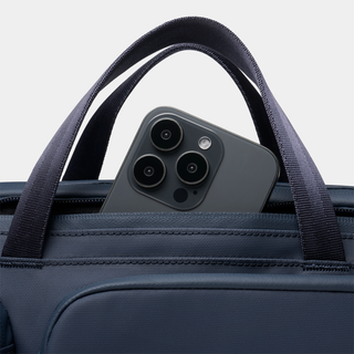 NOMATIC Laptop Bag in navy, close-up of top handles with phone in front pocket
